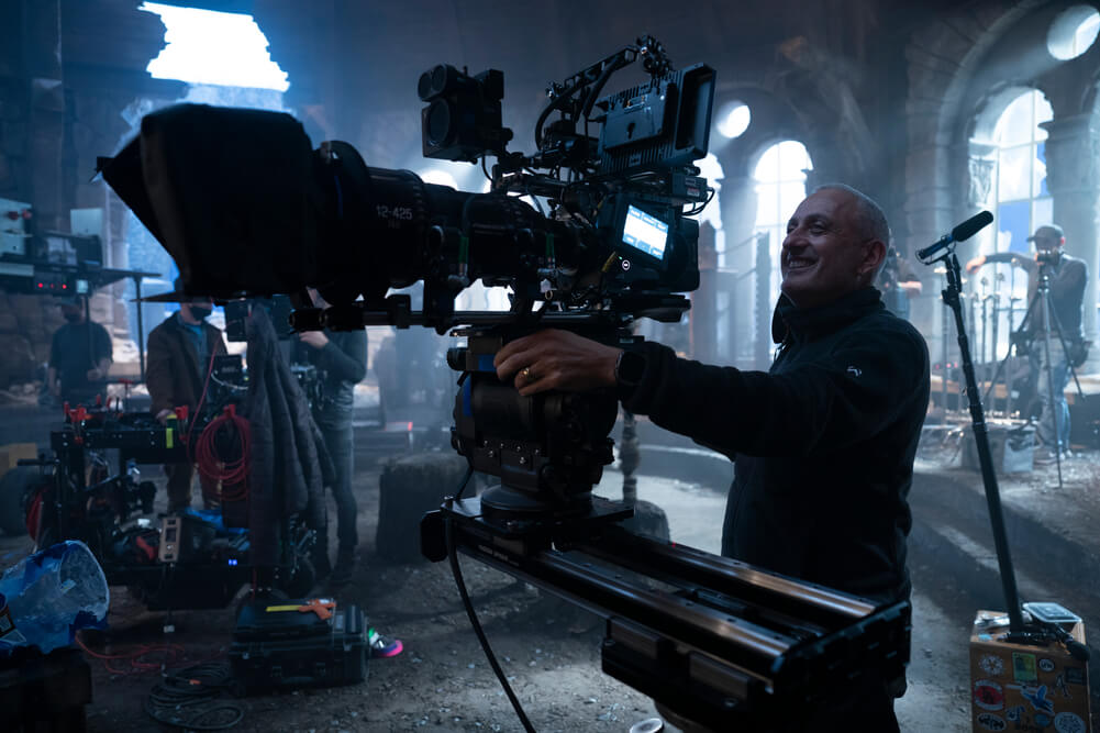 Cinematographer Dan Mindel, ASC, BSC, SASC operates from a dolly track on atmospheric set of 